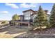 Exterior view of the home with elevated deck space overlooking mature trees and landscaping at 12457 Topaz Vista Way, Castle Pines, CO 80108