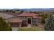 Imposing house with a red tile roof, arched doorway, and beautiful landscaping at 12457 Topaz Vista Way, Castle Pines, CO 80108
