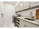 Bright laundry room with sink, stainless steel appliances, and white cabinets at 12457 Topaz Vista Way, Castle Pines, CO 80108