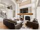 Bright living room with a fireplace, large windows, comfortable seating, and an open layout with stairs at 12457 Topaz Vista Way, Castle Pines, CO 80108