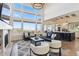 Open-concept living room with fireplace, floor-to-ceiling windows, and views of the kitchen at 12457 Topaz Vista Way, Castle Pines, CO 80108