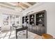 Bright office with large window, custom bookshelves, coffered ceiling, and a modern desk at 12457 Topaz Vista Way, Castle Pines, CO 80108
