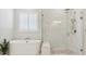 Bathroom featuring a soaking tub, marble tiled shower, and bright window at 547 Scrubjay Cir, Castle Rock, CO 80104