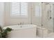 Bathroom featuring a soaking tub, marble tiled shower, and bright window at 547 Scrubjay Cir, Castle Rock, CO 80104