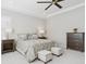 Bright bedroom featuring a tufted headboard, patterned bedding, side tables, dresser and matching cushioned storage benches at 547 Scrubjay Cir, Castle Rock, CO 80104