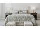 Bright bedroom featuring a tufted headboard, patterned bedding, side tables, and matching cushioned storage benches at 547 Scrubjay Cir, Castle Rock, CO 80104