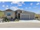 Exterior of home featuring a stone facade, three-car garage, professionally landscaped yard, and mountain views at 547 Scrubjay Cir, Castle Rock, CO 80104