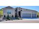 Charming exterior of the home featuring stone accents, a three-car garage, and manicured landscaping at 547 Scrubjay Cir, Castle Rock, CO 80104