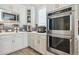 Bright kitchen showcasing stainless steel appliances, white cabinets, and decorative backsplash at 547 Scrubjay Cir, Castle Rock, CO 80104