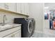 Convenient laundry room featuring sleek appliances, stylish tile floor, sink and ample storage at 547 Scrubjay Cir, Castle Rock, CO 80104