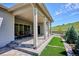 Spacious covered patio with stone steps, artificial turf, and peaceful hillside views at 547 Scrubjay Cir, Castle Rock, CO 80104