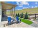 Relaxing outdoor patio with comfortable blue chairs, a grassy area, and scenic views at 547 Scrubjay Cir, Castle Rock, CO 80104