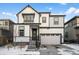 Two-story farmhouse style home with white siding, dark trim, and a two-car garage at 6350 Stable View St, Castle Pines, CO 80108