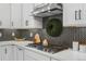 Modern kitchen features gas cooktop, stainless steel appliances, and herringbone tile at 6350 Stable View St, Castle Pines, CO 80108