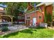 View of the backyard featuring a brick house with a balcony, pergola, and a small patch of grass at 1160 York St, Denver, CO 80206