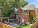View of a backyard with a brick house, a balcony with a garden, a patio with outdoor furniture, and greenery at 1160 York St, Denver, CO 80206