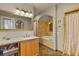 Bathroom featuring a granite countertop, wood cabinets, soaking tub, and decorative mirror at 1160 York St, Denver, CO 80206