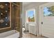 Bathroom with a stone tiled shower, a window, and a classic white toilet at 1160 York St, Denver, CO 80206