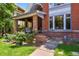 Inviting covered front porch with brick columns and cozy seating area, perfect for relaxing outdoors at 1160 York St, Denver, CO 80206