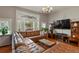 Inviting living room featuring hardwood floors, stained glass windows, and a large television at 1160 York St, Denver, CO 80206