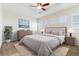 Main bedroom features a ceiling fan and sitting area with a large bed and carpet at 15625 Carob Cir, Parker, CO 80134