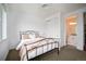 Light-filled bedroom with a wrought iron bed, closet, and a glimpse into the ensuite bathroom at 39 Oneida St, Denver, CO 80230