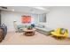 Finished basement with cozy seating, a round coffee table, and a bright accent chair at 4958 Valentia Ct, Denver, CO 80238