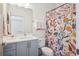 Well-lit bathroom with a sleek vanity, modern fixtures, and a vibrant patterned shower curtain at 4958 Valentia Ct, Denver, CO 80238