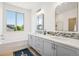 Bright bathroom features double vanity, modern lighting, large window and soaking tub at 4958 Valentia Ct, Denver, CO 80238