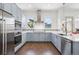 Stylish kitchen with stainless appliances, blue cabinetry, and quartz countertops, offering a modern and functional design at 4958 Valentia Ct, Denver, CO 80238