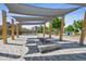 Inviting outdoor area with shaded seating beneath a pergola and unique fire pit feature at 4958 Valentia Ct, Denver, CO 80238