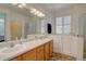 Bright bathroom featuring double sinks, a large mirror, a tub with window view, and a walk-in shower at 10588 Parkington Ln # 39A, Highlands Ranch, CO 80126