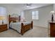 A cozy bedroom with a ceiling fan, wooden furniture, neutral colors, and a bright window at 10588 Parkington Ln # 39A, Highlands Ranch, CO 80126