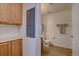Hallway view of a bathroom with a toilet and sink adjacent to wooden cabinets at 10588 Parkington Ln # 39A, Highlands Ranch, CO 80126