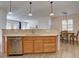 Open kitchen with stainless steel appliances, light wood cabinets, and a view of the dining and living areas at 10588 Parkington Ln # 39A, Highlands Ranch, CO 80126