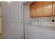 Bright laundry room with washer, dryer, and a storage cabinet above appliances at 10588 Parkington Ln # 39A, Highlands Ranch, CO 80126