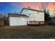 Backyard featuring a two-story home, wooden deck, and exterior lighting at sunset at 14552 E Tufts Ave, Aurora, CO 80015