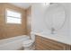 Bathroom featuring wood grain vanity, a round mirror, and a tub shower combo at 14552 E Tufts Ave, Aurora, CO 80015