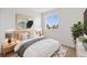 Well-lit bedroom featuring a bed, nightstands, tasteful decor and a view to the outside at 14552 E Tufts Ave, Aurora, CO 80015