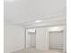 Bright bedroom featuring all-white walls and carpet, two closets with folding doors, and overhead lighting at 14552 E Tufts Ave, Aurora, CO 80015