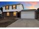 Charming two-story home with a brick facade, white siding, and an attached two-car garage at 14552 E Tufts Ave, Aurora, CO 80015