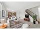 Bright living room with stylish decor, built-in bookshelves, and a staircase leading to the upper level at 14552 E Tufts Ave, Aurora, CO 80015