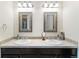 Bathroom features dual sinks, decorative mirrors, and tile backsplash at 1640 Aspen Meadows Cir, Federal Heights, CO 80260