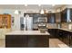 Stylish kitchen featuring stainless steel appliances, dark wood cabinets, and a central island with granite countertops at 1640 Aspen Meadows Cir, Federal Heights, CO 80260
