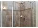 Shower with glass doors and earth-toned tile at 1640 Aspen Meadows Cir, Federal Heights, CO 80260