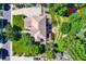 Top-down aerial view of a home with a spacious yard, paved driveway, and a patio seating area at 7355 Nile St, Arvada, CO 80007