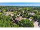 Expansive aerial view of a residential neighborhood with mature trees, green spaces, and a golf course in the distance at 7355 Nile St, Arvada, CO 80007