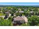 This aerial view showcases the property surrounded by mature trees, with a glimpse of a deck and spacious yard below at 7355 Nile St, Arvada, CO 80007