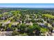 Picturesque aerial view showcasing houses surrounded by green landscape, mature trees, and a scenic pond in a residential area at 7355 Nile St, Arvada, CO 80007