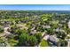 Scenic aerial shot of a neighborhood with houses nestled among lush trees and a tranquil lake in the background at 7355 Nile St, Arvada, CO 80007